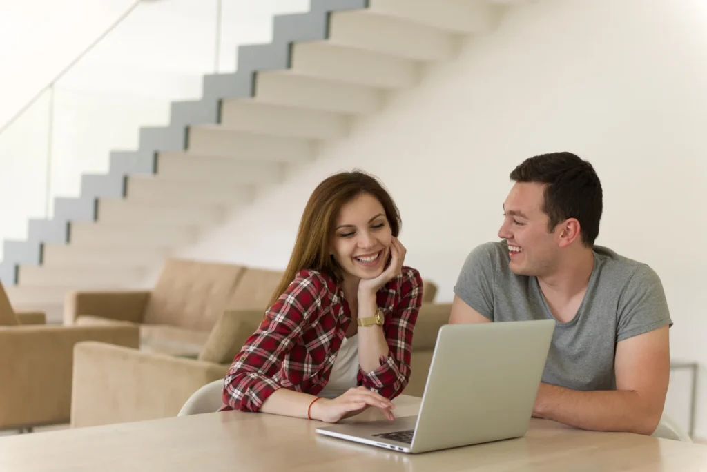 Happy-young-couple-buying-online-using-laptop-a-computer-and-a-credit-card-in-their-luxury-home-villa-1767014506618.webp