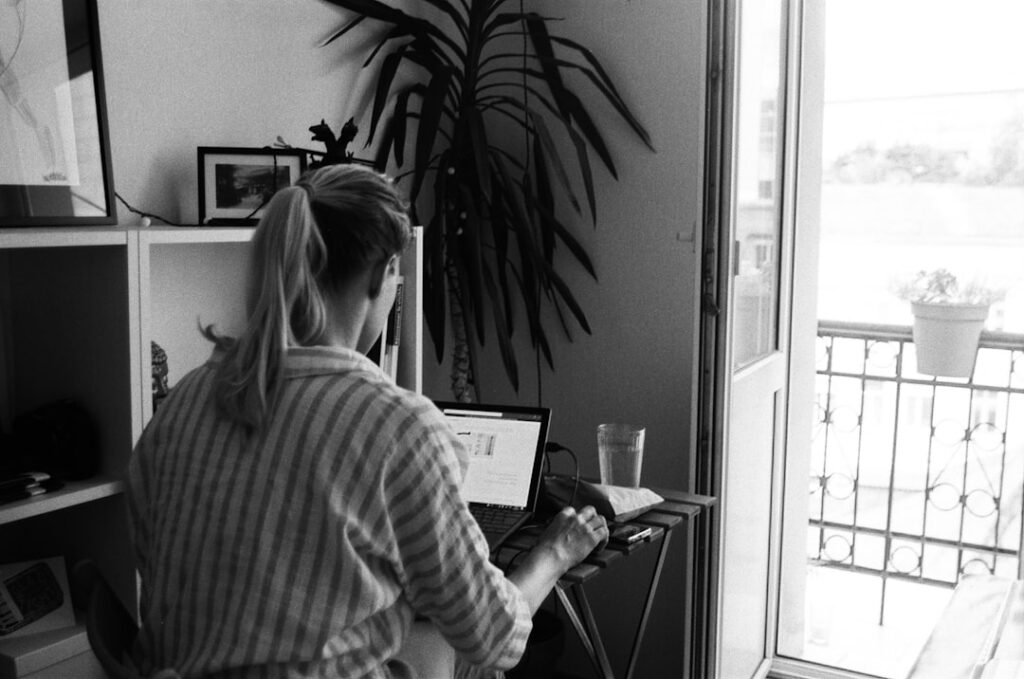 Person sits at a bright, modern desk, using a calculator next to a set of house keys, contemplating a home financial decis...