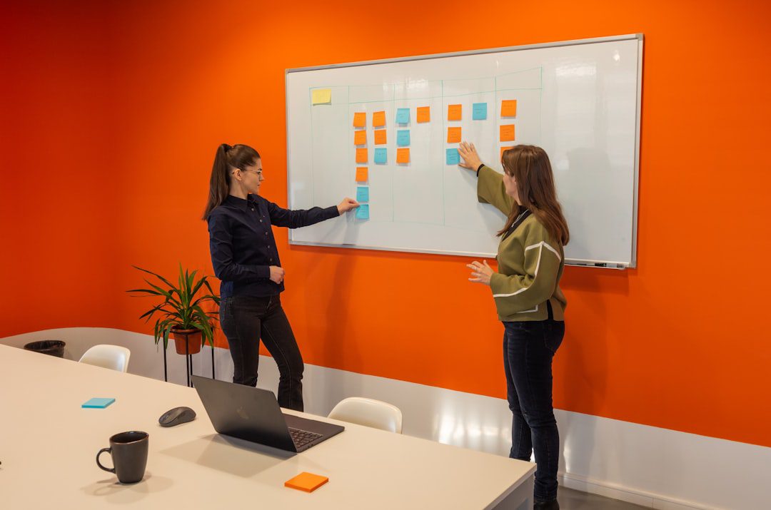 A professional business team collaborating and planning around a table in a modern office environment.. Photo by Paymo on Unsplash. A professional business team collaborating and planning around a table in a modern office environment.