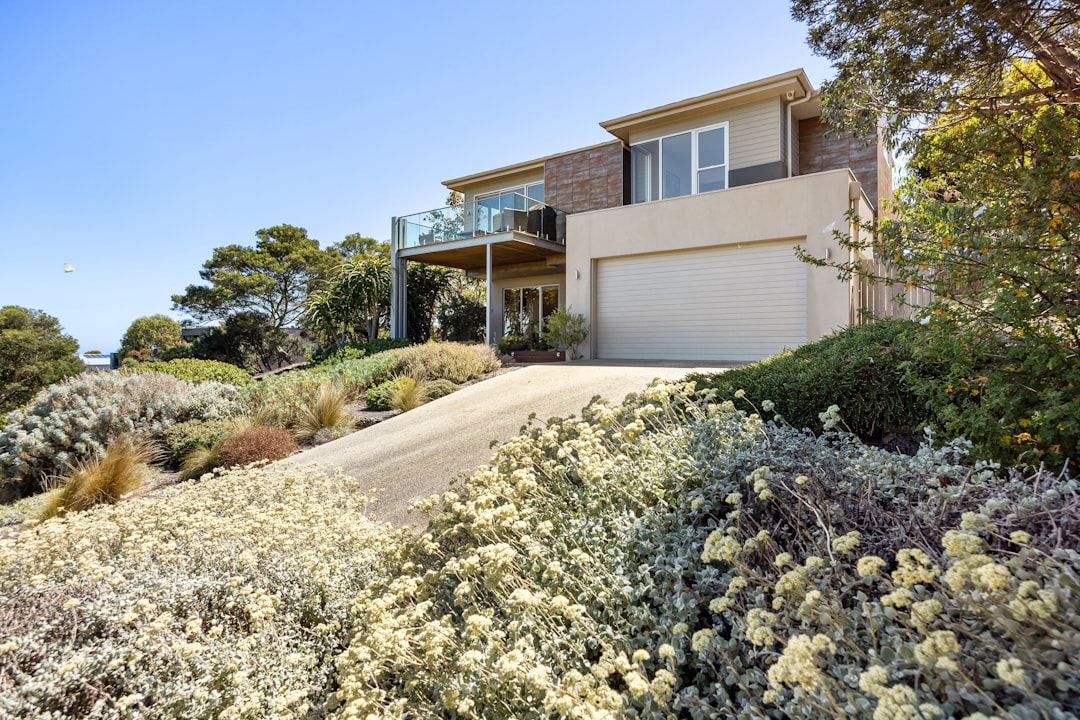 A beautiful, modern suburban house under a clear blue sky, representing the valuable rental property asset at the center of a landlord's decision.