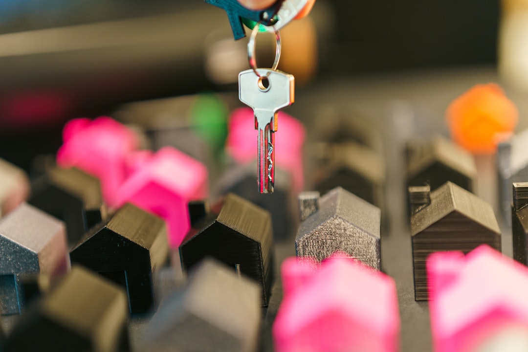 A close-up shot of a person's hands holding a set of sleek, modern house keys, with the blurred background of a beautiful home, representing the value and security of the property.