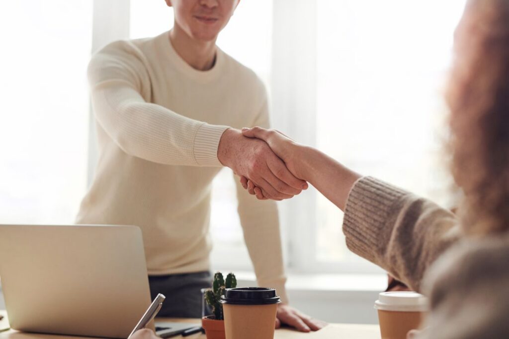 Diverse team of professionals in business attire collaborating around a conference table in a modern, sunlit office, repre...