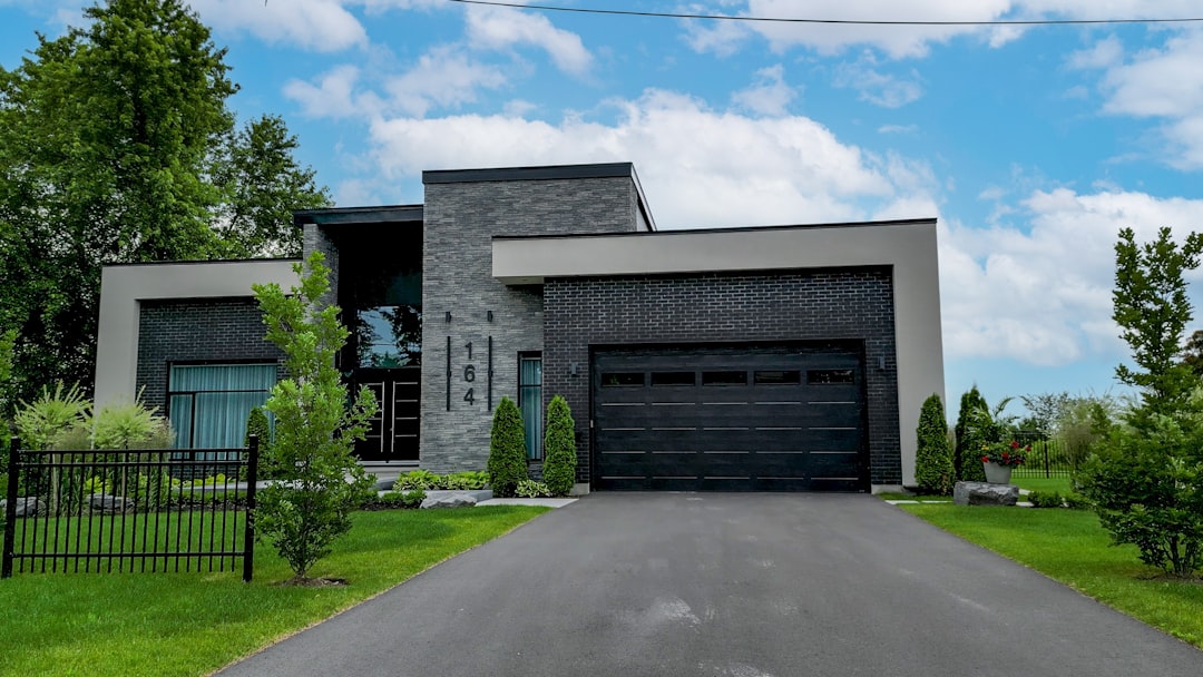 A beautiful, modern single-family home with a 'Sold' sign in the front yard on a bright, sunny day, signifying a successful and profitable real estate transaction.