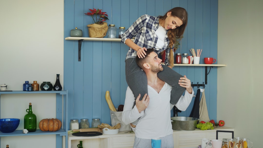 A happy couple smiling and relaxing in their bright, modern, and clean kitchen, representing the successful outcome of a smooth home buying and selling process.