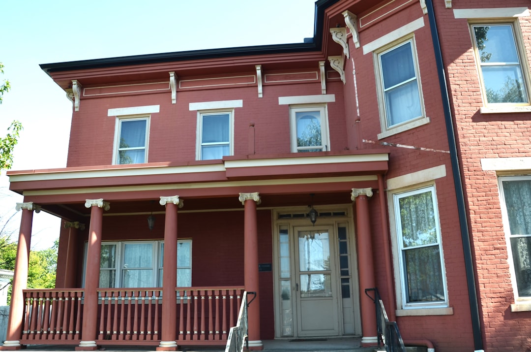 A peaceful suburban home with a tidy front porch, seen in the soft light of a quiet morning, representing an inherited property waiting for a decision.