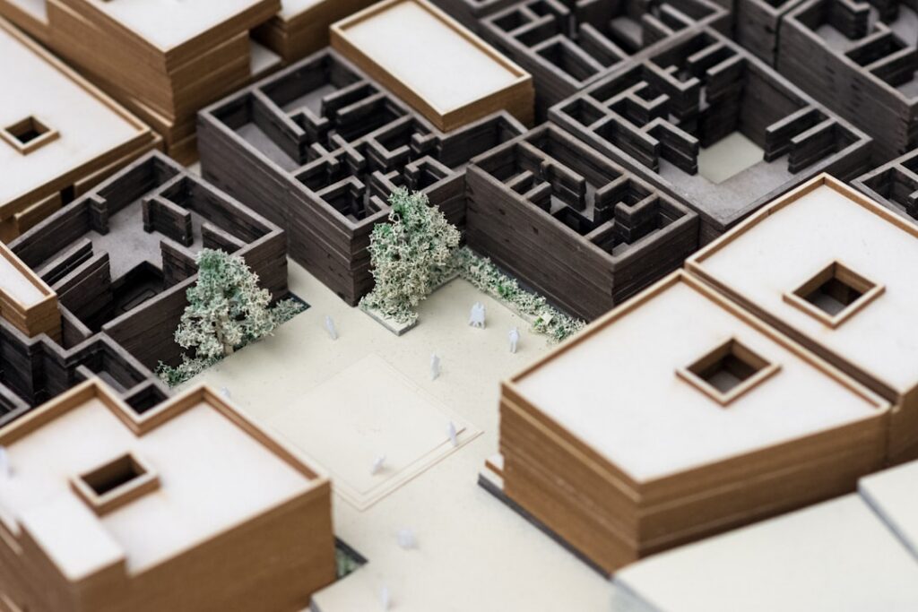 Professional and modern desk setup with two distinct miniature house models, representing the complex decision of selling ...