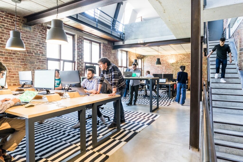 Diverse team of marketing and real estate specialists collaborating around a large table in a bright, modern office, repre...