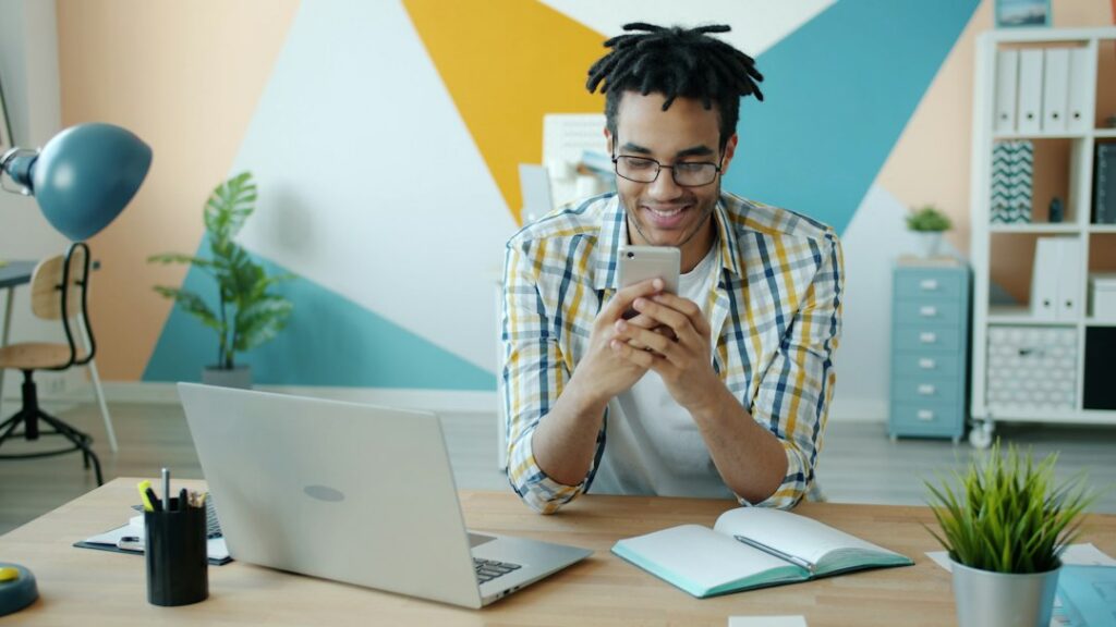 Professional person looking stressed and overwhelmed while multitasking with a laptop, phone, and stacks of paperwork at a...