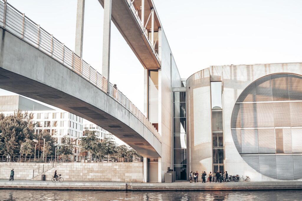 Sleek, modern bridge with clean architectural lines spanning a wide river under a bright, sunny sky, symbolizing a seamles...