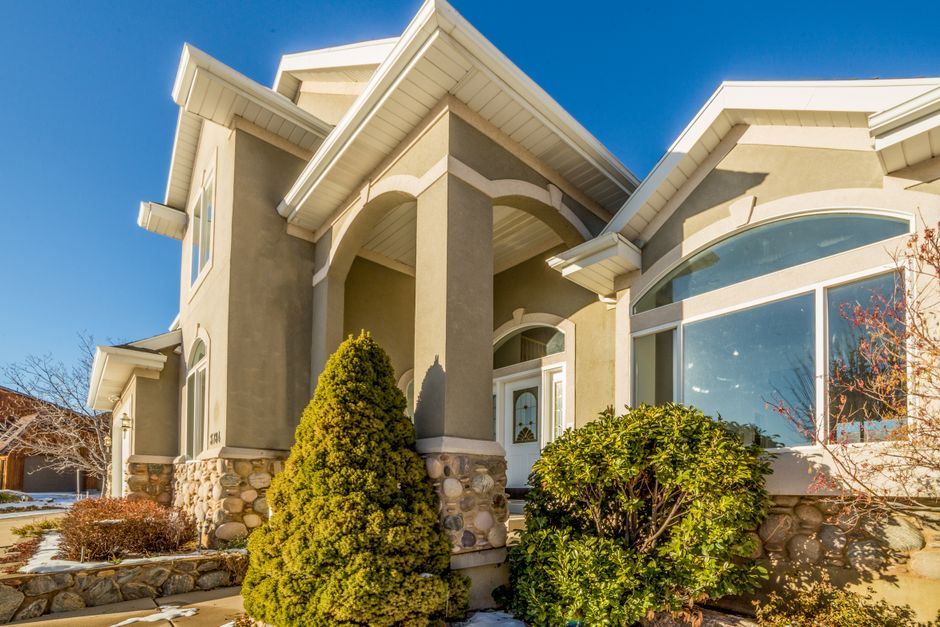 The beautiful exterior of a modern suburban home, typical of the Tri-Cities area, with clean architectural lines and a manicured lawn under a clear blue sky with bright sunlight.
