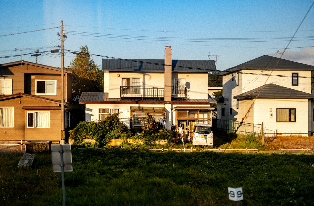 A beautiful modern suburban home with a 'Sold' real estate sign in the manicured front lawn on a sunny day, representing a successful home sale.