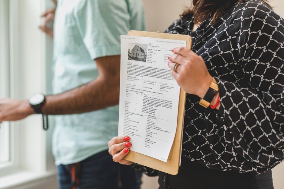 A close-up, professional shot of a person using a magnifying glass to carefully inspect the fine print on a real estate contract, symbolizing due diligence and scrutiny.