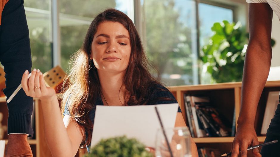 A focused person sits at a modern desk carefully reviewing documents, symbolizing a homeowner scrutinizing an agent's qualifications and track record.