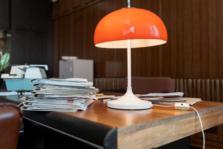A neat stack of professional file folders, representing multiple offers, sits on a clean, minimalist desk next to a laptop, symbolizing an organized, data-driven process.